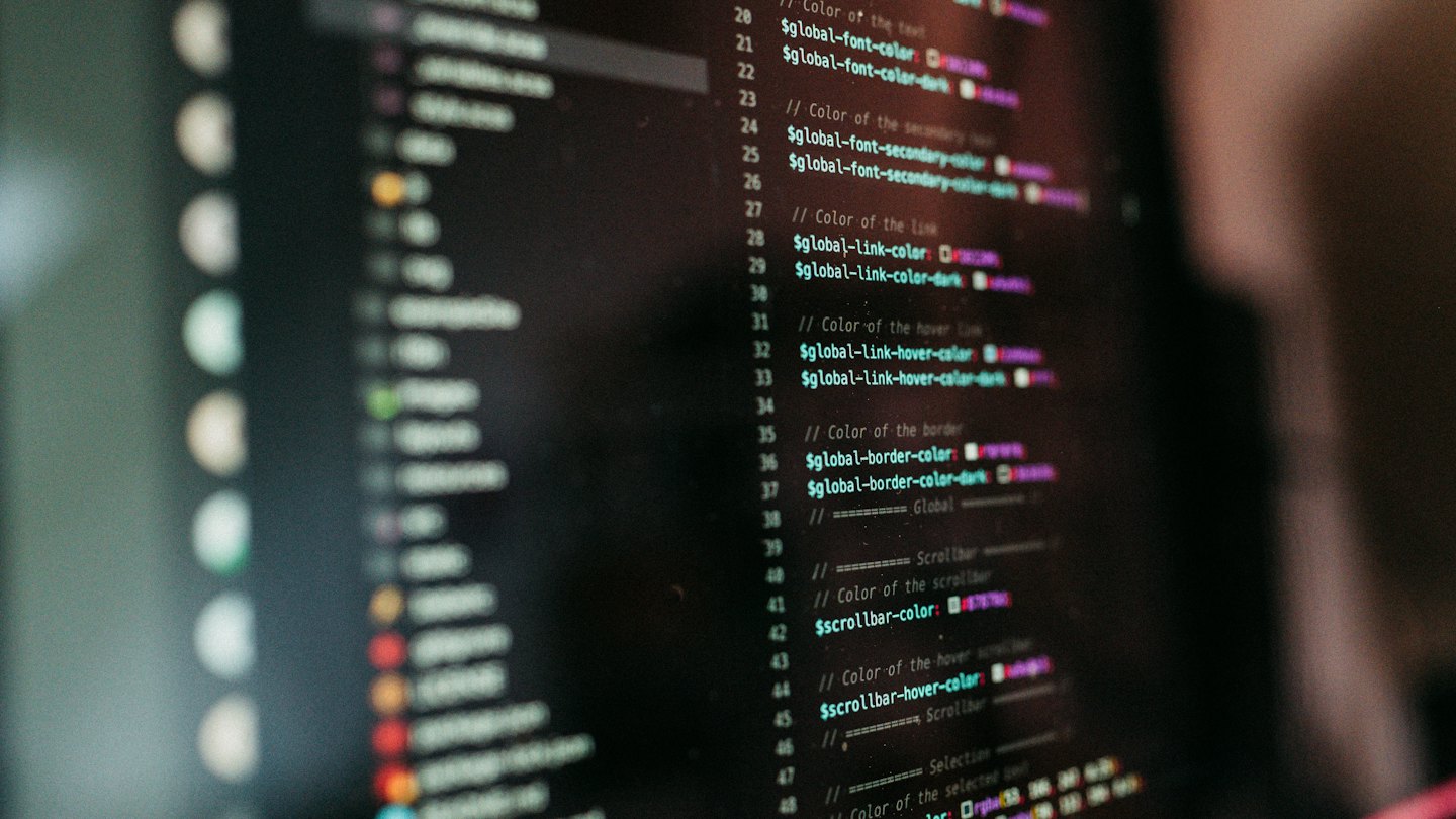 Computer monitor displays lines of code with syntax highlighting.