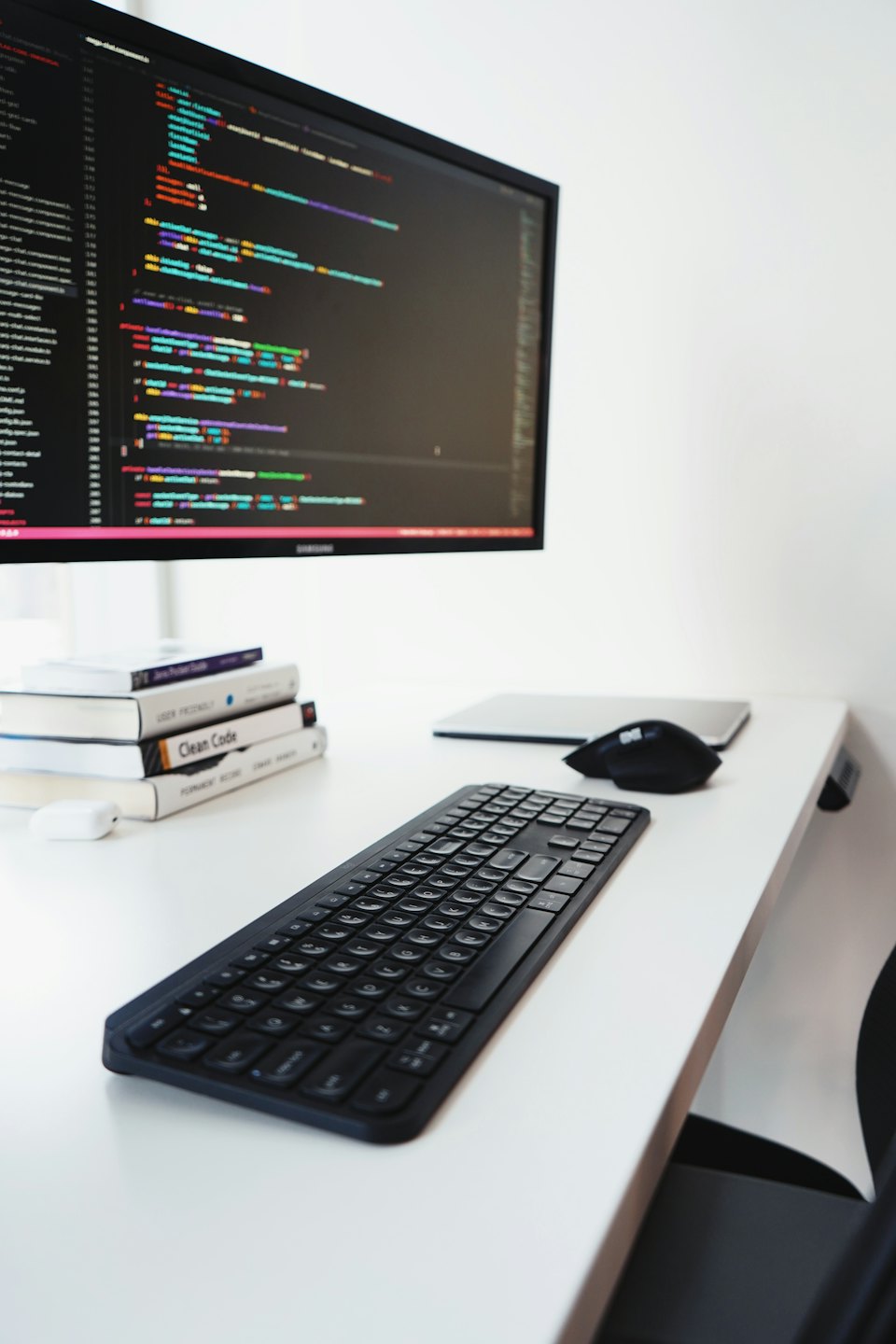 Computer monitor showing colorful code on a programmer's desk.